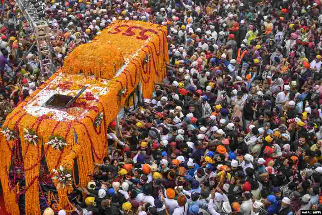 Sikh devotees gather around a bus carrying the Guru Granth Sahib, the Sikh holy book, during a religious procession on the occasion of the birth anniversary of Guru Nanak Dev, the founder of Sikhism, in Punjab Province, Pakistan, on November 15.