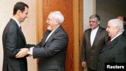 Syrian President Bashar al-Assad (left) welcomes Iranian Foreign Minister Mohammad Javad Zarif before a meeting in Damascus on January 15.