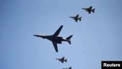 Американский стратегический бомбардировщик В-1B в сопровождении истребителей поднимается над авиабазой Осан, 13 сентября 2016 года. 