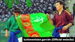 Turkmen wrestlers carry the national flag at the opening ceremony of the Asian Indoor and Martial Arts Games in Ashgabat on September 17.