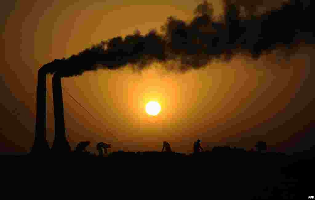 Afghan laborers work at a brick factory as the sun sets on the outskirts of Mazar-e Sharif. (AFP/Farshad Usyan)