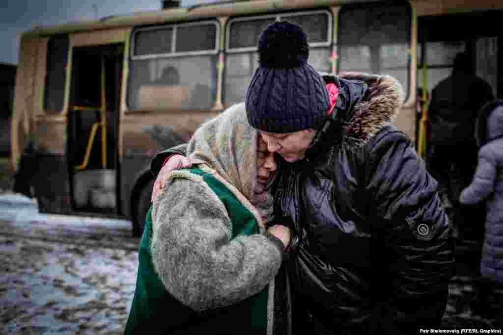 Women prepare to board a bus to leave the town on February 4.