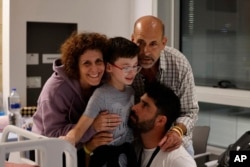 اوهاد موندر ۹ساله در کنار خانواده‌اش در یک مرکز پزشکی کودکان، پس از آزادی