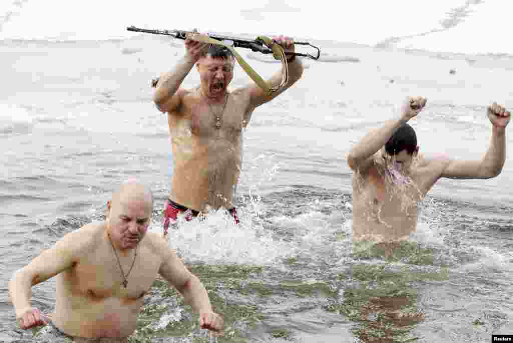Ukrainian army veterans take a dip in the freezing waters of the Dnieper River during Orthodox Epiphany celebrations in Kyiv on January 19. (REUTERS/Vladimir Sindeyev).