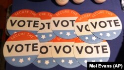 U.S. -- Computer mouse pads with Secure the Vote logo on them are seen on a vendor's table at a convention of state secretaries of state in Philadelphia, July 14, 2018