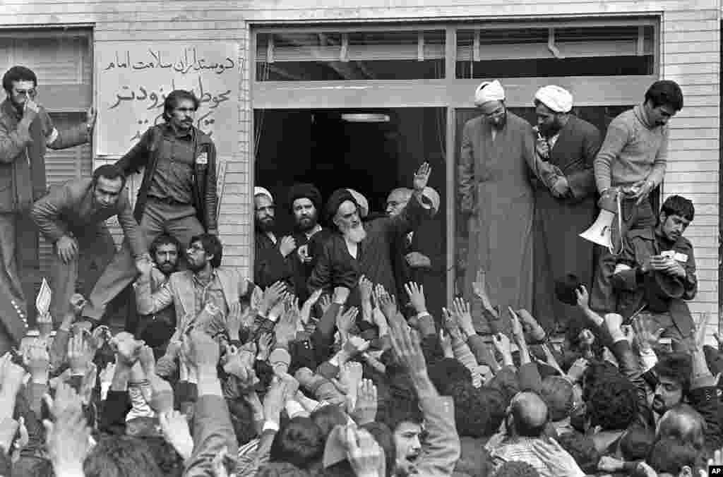 Khomeini waves to followers as he appears on the balcony of his headquarters in Tehran on February 2, 1979.