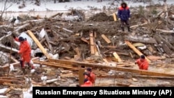 Rescue workers search for bodies after a dam collapsed near the village of Shchetinkino in the Krasnoyarsk region on October 19.