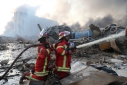 Кое-где в порту Бейрута еще тлеют оставшиеся очаги пожара, что мешает спасателям