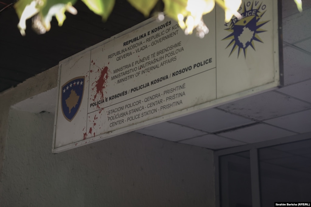 Tabela në hyrje të stacionit të Policisë së Kosovës në Prishtinë ngjyroset me bojë të kuqe nga protestuesit.Policia e arrestoi më 27 tetor të dyshuarin për vrasjen e Zekajt, ndërsa bashkëshorti i saj po mbahet në paraburgim për "kanosje", pasi ishte ndaluar nga policia para se të ndodhte vrasja.