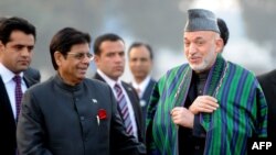 Afghan President Hamid Karzai (right) arrives at New Delhi's Palam Airport.