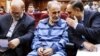 Mohammad Ali Najafi (center) in handcuffs in a Tehran court