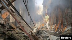 Residents gather at a market destroyed after an attack by Iraqi security force helicopters in Ramadi in June during fighting with Islamic State militants.