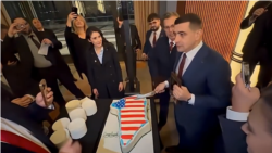 George Simion în timp ce taie un tort în forma Groenlandei, în timpul unei deplasări în Statele Unite ale Americii. 