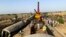 Workers clear the wreckage from a railroad track in Sindh Province on June 8, a day after a packed inter-city train ploughed into another express train that had derailed.