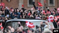 Mulțimea filmează cu mobilele automobilul cu care noul cuplu regal danez se deplasează spre castelul Christiansborg, unde are loc abdicarea reginei. ( Foto: Jonathan NACKSTRAND / AFP)