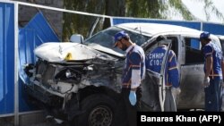 Pakistani volunteers search a destroyed vehicle of a police officer at the site of a suspected suicide bomb attack in Quetta on November 9.