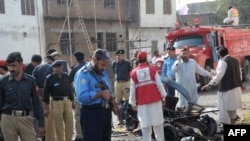 Police officials examine the site of a suicide bomb blast in Peshawar on November 9.