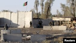 Afghan security forces stand guard at the entrance gate of Kandahar Airport on December 9.