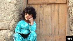 An Afghan girl sits outside her house in Kabul (file photo)