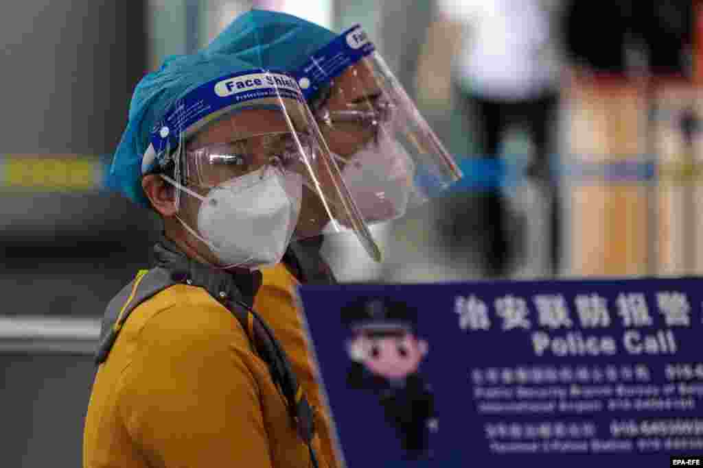 Працівники аеропорту в захисних масках в терміналі №3 міжнародного аеропорту Пекіна, Китай, 17 червня 2020 року. Пекін скасував понад 1200 рейсів на тлі нових випадків коронавірусу
