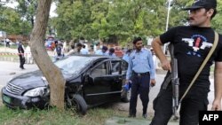 Police inspect the bullet-riddled car of Religious Affairs Minister Hamid Said Kazmi in Islamabad.