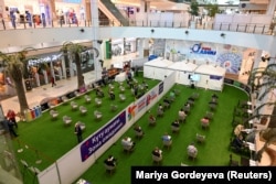 People wait their turn before entering a vaccination center located at a shopping mall in Almaty. More than 1 million people in Kazakhstan -- about 5.7 percent of the population -- have received at least one dose of a coronavirus vaccine.