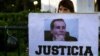 A woman holds a sign reading "Justice" during a demo at Mayo square, in Buenos Aires on January 26, 2015