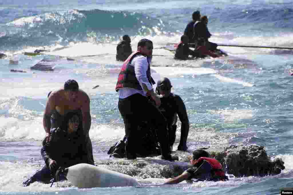 Migrants trying to reach Greece are rescued by members of the Greek Coast Guard and local residents near the coast of the southeastern island of Rhodes. A wooden sailboat carrying dozens of immigrants ran aground April 20 off Rhodes. At least three people drowned. As many as 900 people may have died in a migrant boat disaster off the coast of Libya on April 19. (Reuters/Argiris Mantikos/Eurokinissi)