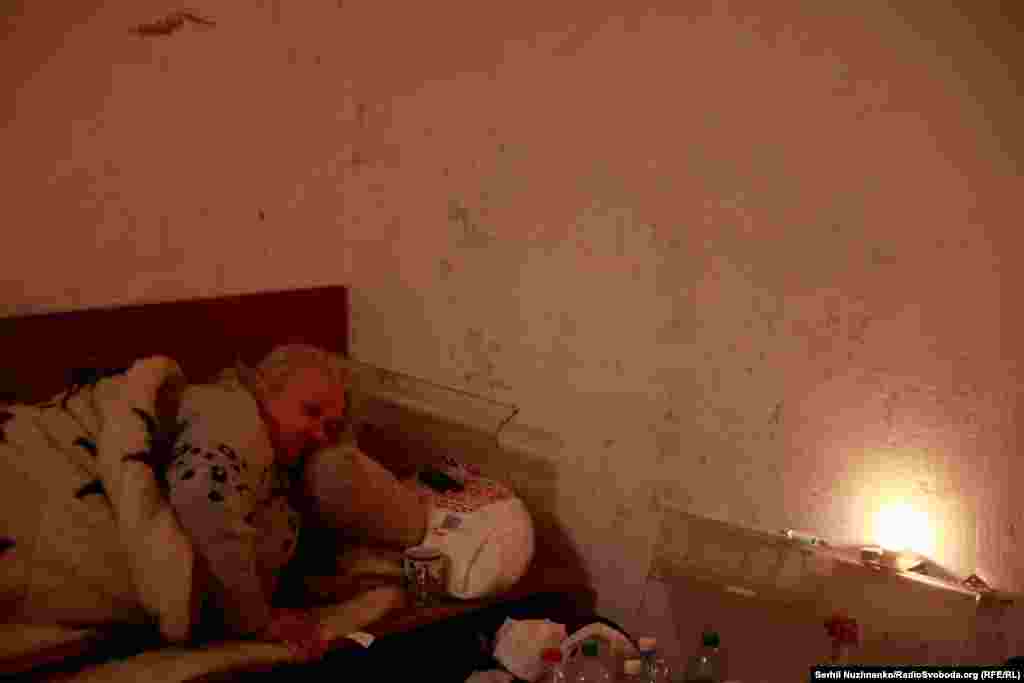 Жінка в укритті в одному з багатоквартирних будинків Ірпеня, неподалік окупованої Бучі, 12 березня 2022 року