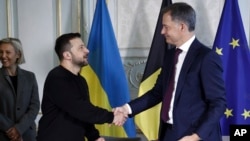 Președintele ucrainean Volodimir Zelenski și premierul belgian Alexander De Croo își dau mâna după semnarea unui acord bilateral de securitate la Bruxelles, pe 28 mai.