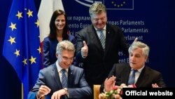 Ukrainian President Petro Poroshenko (top right) looks on as he attends the signing ceremony for a new visa-liberalization regime with the European Union in Strasbourg on May 17.