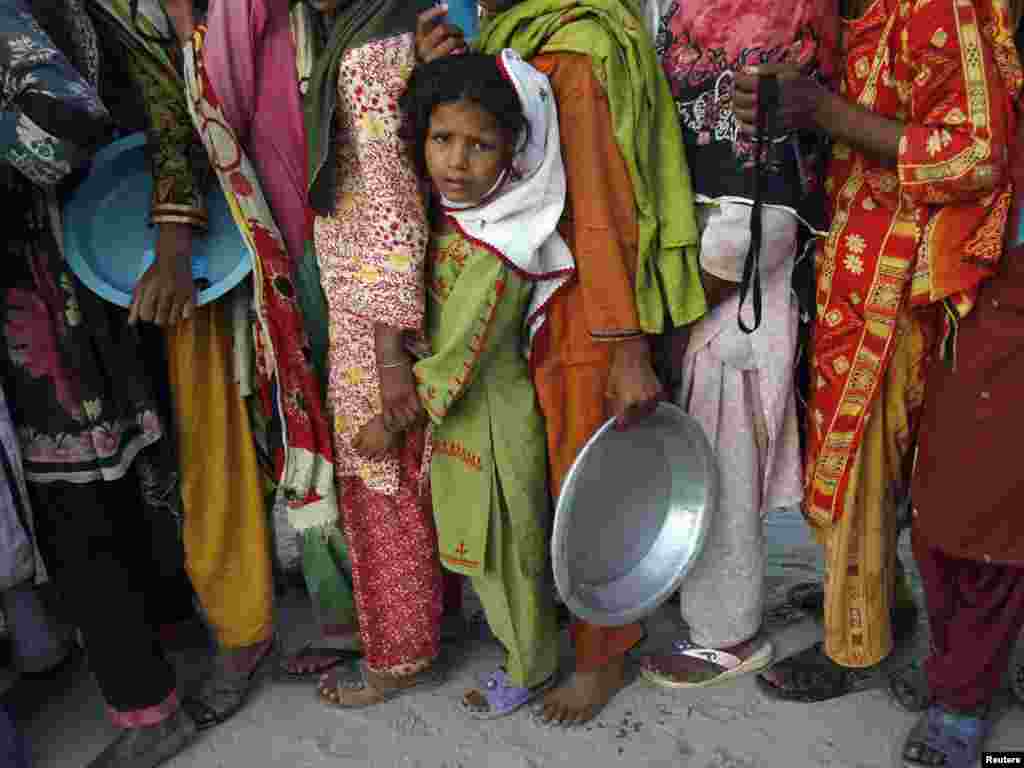 A flood victim stands in queue with others to get food handouts while taking refuge with her family in a relief camp for flood victims in Sukkur, in Pakistan's Sindh Province, on August 27. Photo by Athar Hussain for Reuters