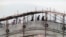 BOSNIA-HERZEGOVINA -- Residents pass over a more than 500-year-old bridge over the Neretva River, which is protected with wooden scaffolding, in the old part of the Bosnian city of Mostar, April 12, 1993
