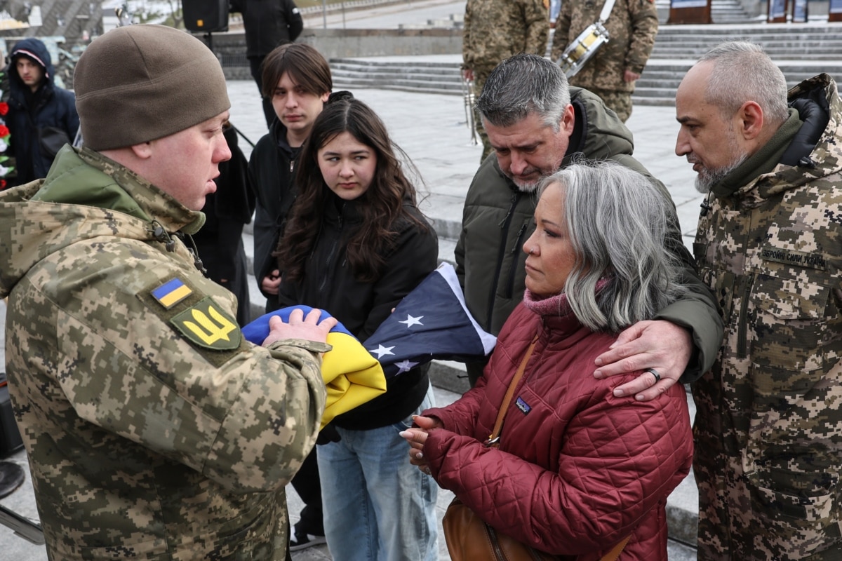 Леслі та Джон Гертвеки, батьки 21-річного Ітана Гертвека, отримують прапор України, яким була вкрита домовина з тілом їхнього сина під час церемонії прощання на майдані Незалежності в Києві, лютий 2025 року