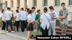 Elevi în curtea unui liceu din Chișinău în perioada susținerii examenelor de Bacalaureat, iunie 2024.