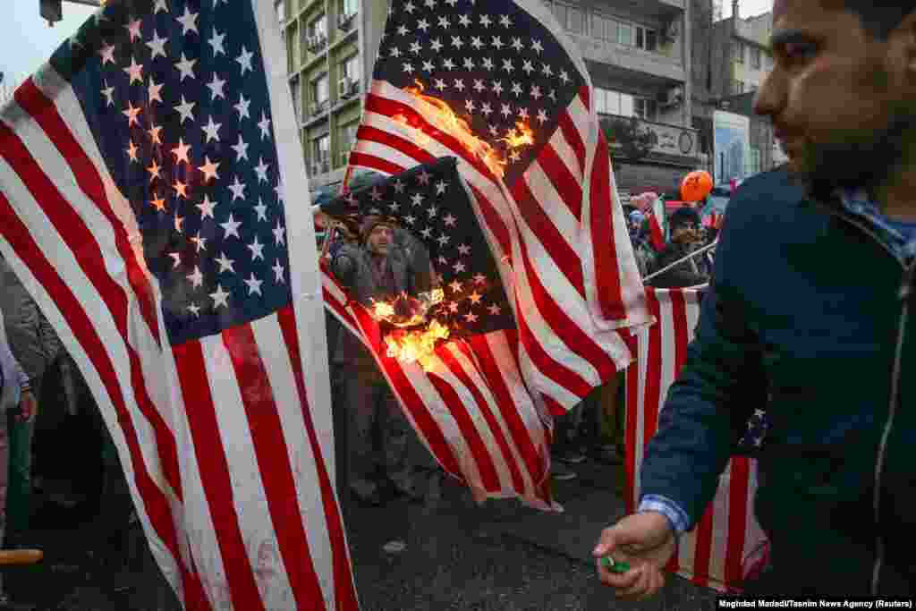 Iranians burn U.S. and Israeli flags in Tehran.