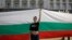Девојка држи огромно бугарско знаме за време на протестот во септември 2020 година пред зградата на парламентот во Софија