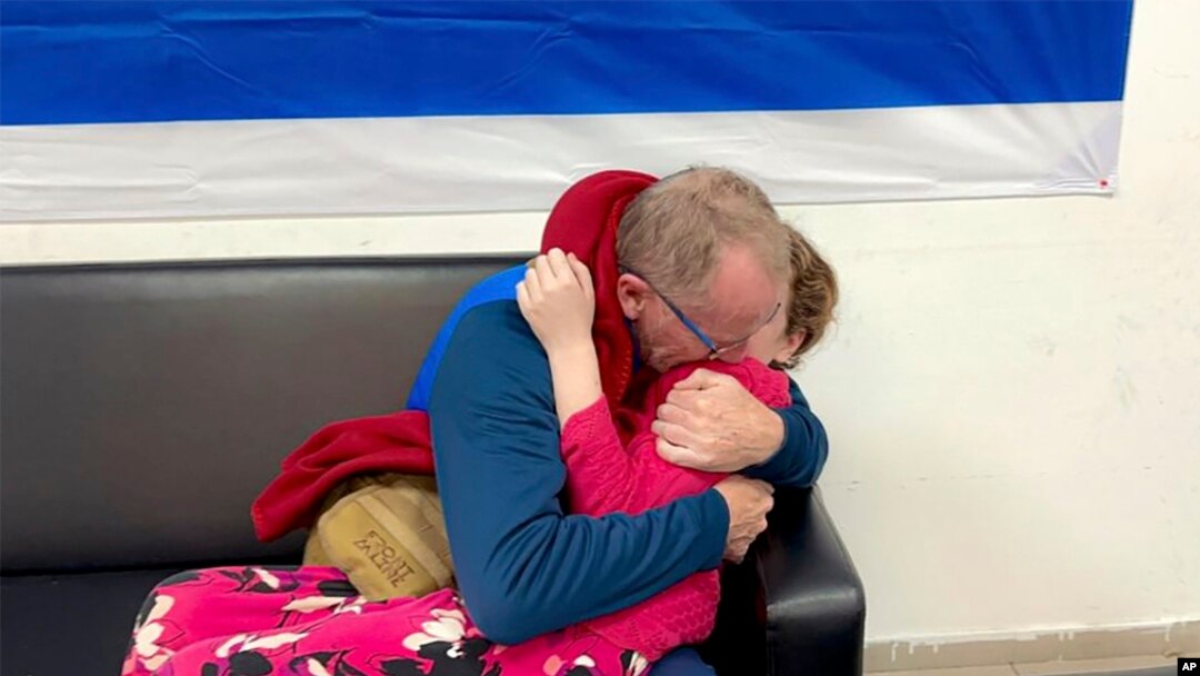 Fetiţă care a fost deţinută ostatică de Hamas, la reîntâlnirea cu tatăl ei, în Israel, duminică.