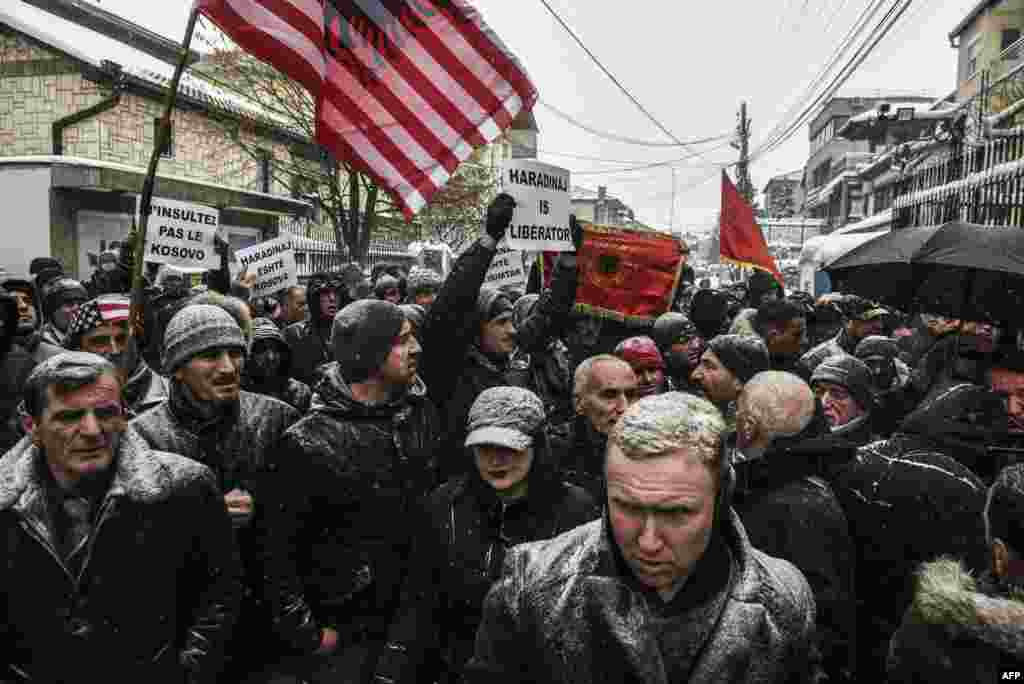 Protesters hold a combined U.S. and Albanian flag and placards, including one reading "Do Not Insult Kosovo," during a protest by Kosovar Albanians in front of the French Embassy in Pristina after Kosovo's former Prime Minister Ramush Haradinaj was arrested in France on January 4 in response to an international arrest warrant for war crimes filed by Serbia. (AFP/Armend Nimani)