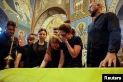 Rudele și prietenii Victoriei Amelina, la înmormântarea tinerei autoare.