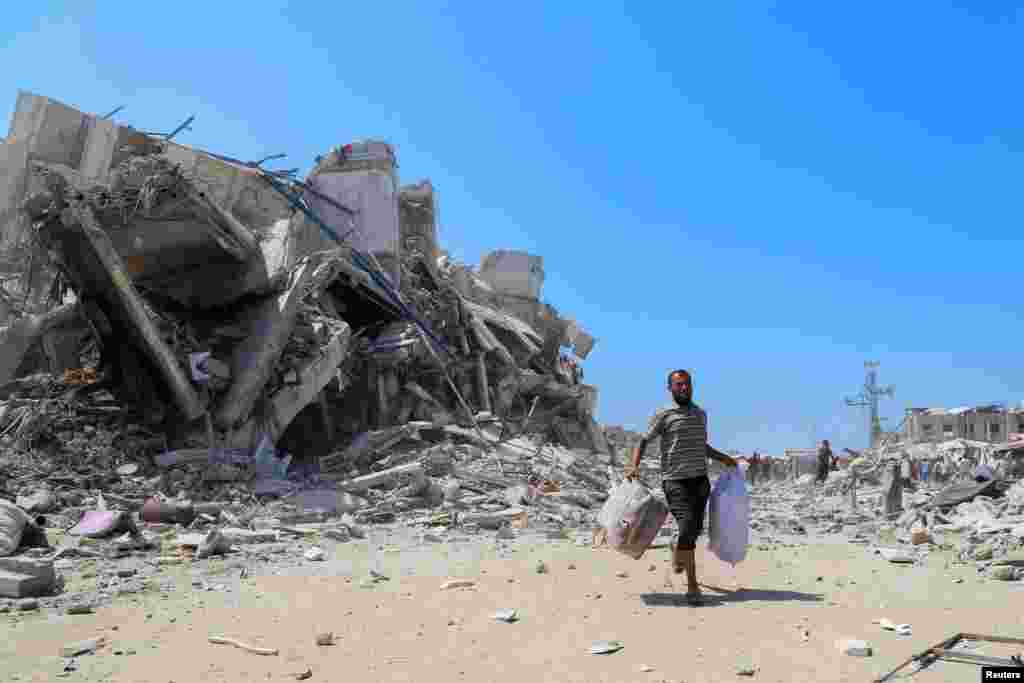 Un palestinian aleargă cu puținele sale bunuri după ce o clădire a fost lovită de un atac aerian israelian, în orașul Gaza, pe 5 septembrie 2025.