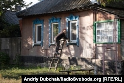 Мешканка Кримського ущільнює нові пластикові вікна перед сезоном холодів, вересень 2021 року