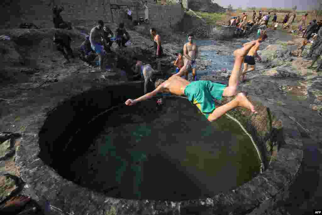 Iraqis and members of Iraqi forces bathe in a sulfur pond some 14 kilometers from the southern outskirts of Mosul. (AFP/Ahmad Al-Rubaye)