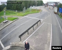 A man, believed to be Belarusian opposition politician Mikalay Statkevich, sits in the no man's zone at the Lithuania border crossing