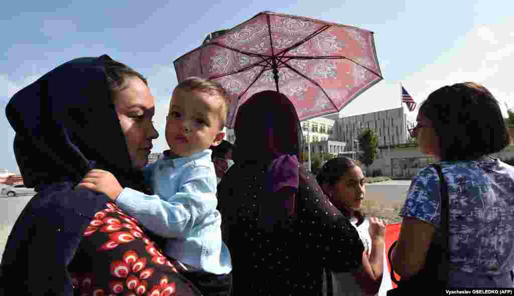 Një grua afgane duke mbajtur një fëmijë gjatë një tubimi para ambasadës së Shteteve të Bashkuara të Amerikës, në Bishkek, Kirgizi. (19 gusht)