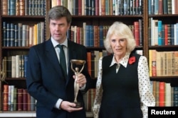 Тазгодишният носител на наградата „Букър“ Дейвид Салаи заедно с кралица Камила в Лондон, 11 ноември 2025 г.