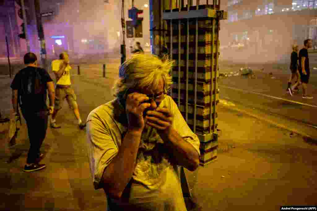 Un bărbat încearcă să se protejeze după ce Jandarmeria a dispersat gaze în întreaga zonă a Pieței Victoriei.&nbsp;&nbsp;