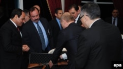 Egyptian President Abdel Fattah al-Sisi (left) receives a Kalashnikov assault rifle as a gift from Russian President Vladimir Putin (second from right) in Cairo on February 9.