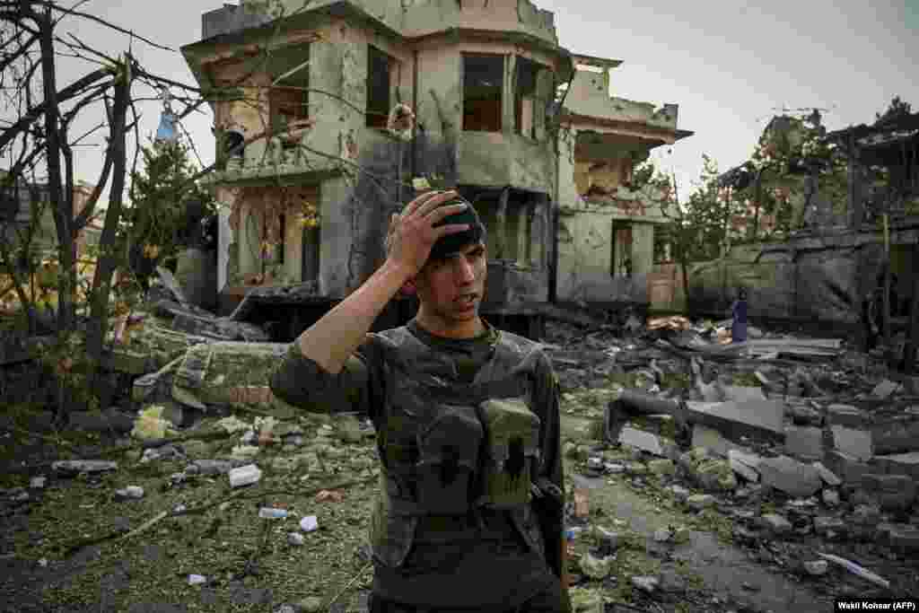 Një oficer afgan i sigurisë mban kokën derisa bën roje në vendin e një shpërthimi të një makine-bombë në Kabul, 4 gusht, 2021.