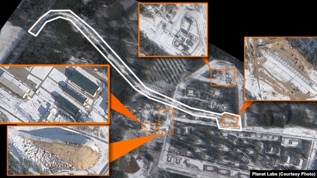 Imazhi satelitor tregon zonat e ndërtuara rishtas dhe të rindërtuara me ngjyrë portokalli dhe linjën hekurudhore me të bardhë.